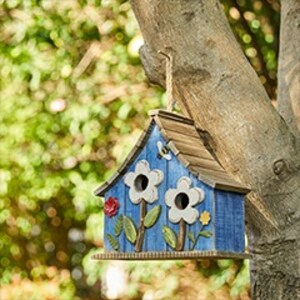 Blue birdhouse with flower design in a tree